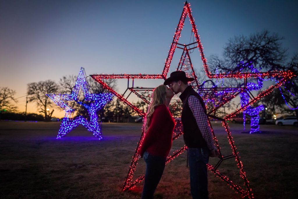 A couple kissing with Christmas Lights in the Background