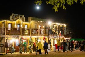 Old West town storefronts glowing with Christmas lights at Old West Christmas Light Fest in Boerne, TX