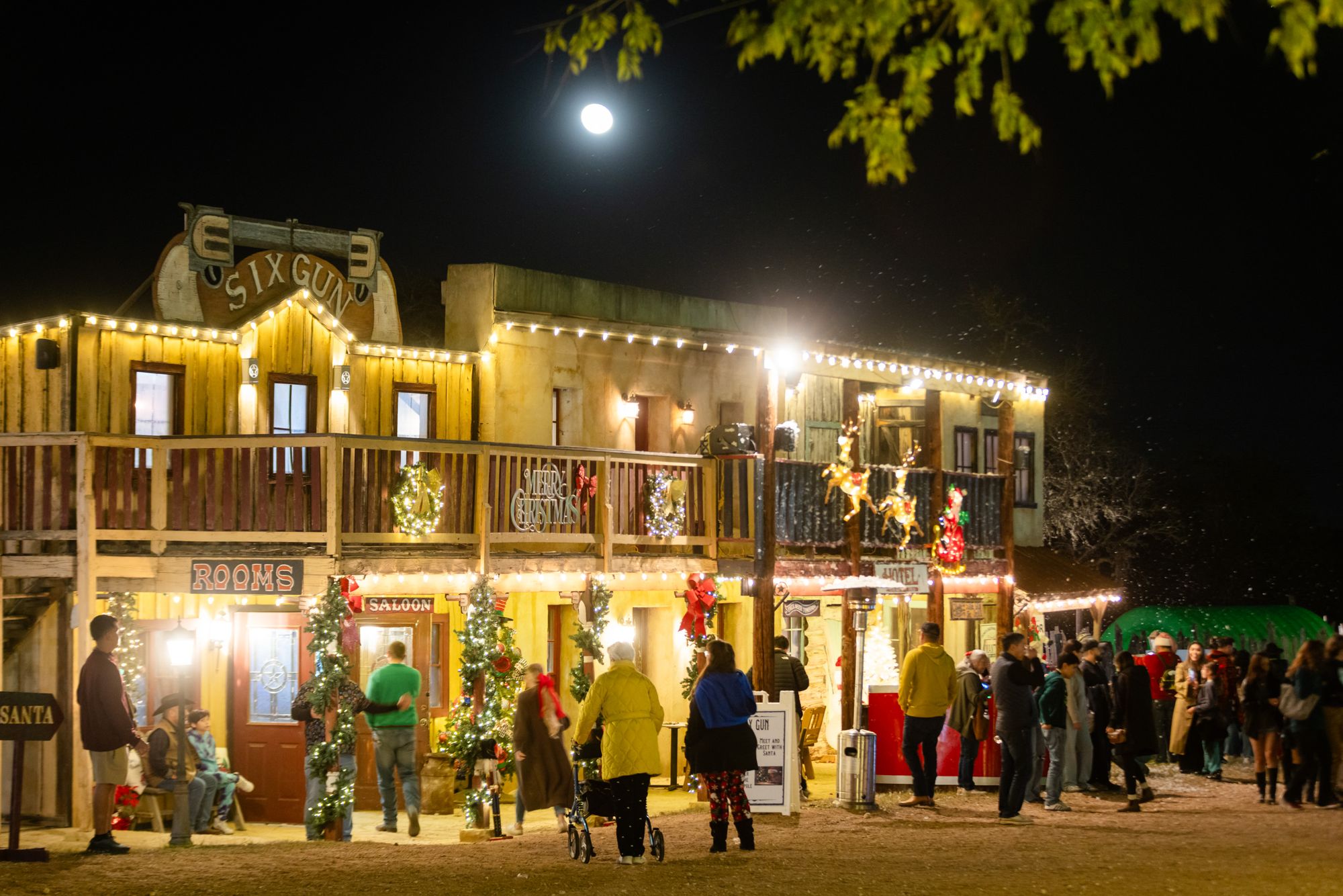 Old West town storefronts glowing with Christmas lights at Old West Christmas Light Fest in Boerne, TX
