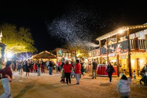 Snow falling over the crowd in the Old West town at Christmas Light Fest near San Antonio