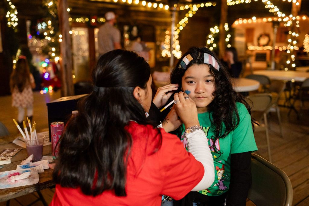 Glitter face painting at Old West Christmas Light Fest
