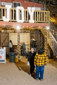 Guests in front of the JOY sign in the Old West town at Christmas