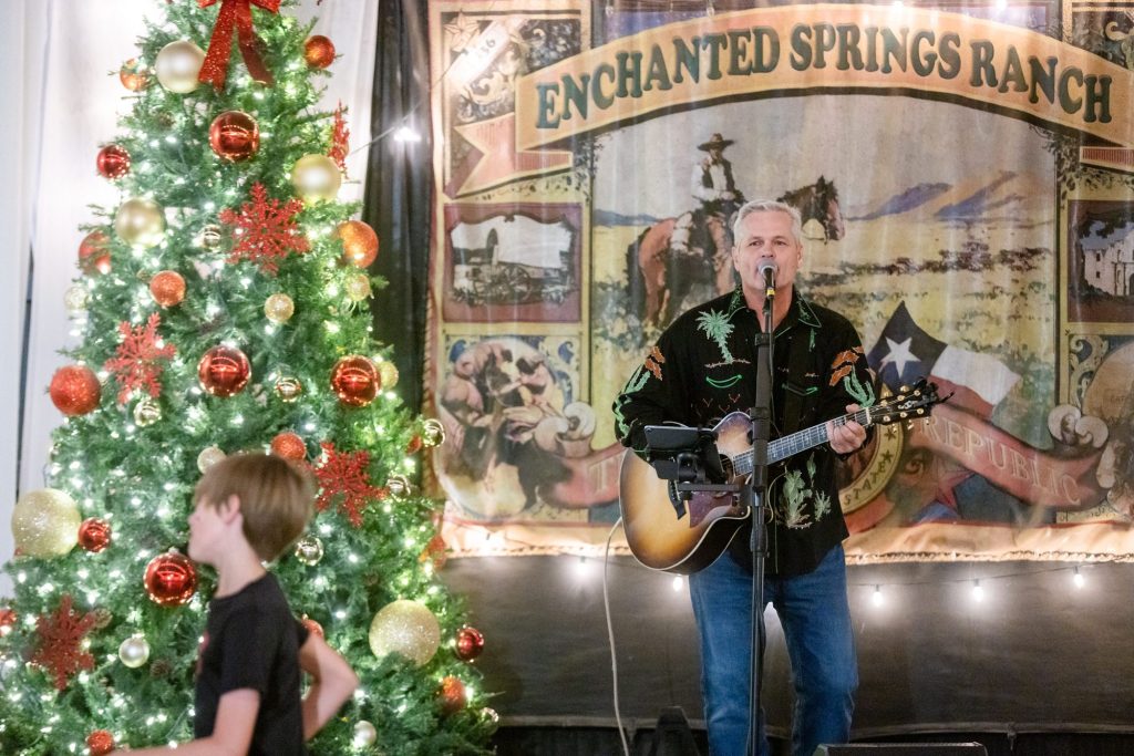 Musician performing on stage at Enchanted Springs Ranch during Christmas Light Fest
