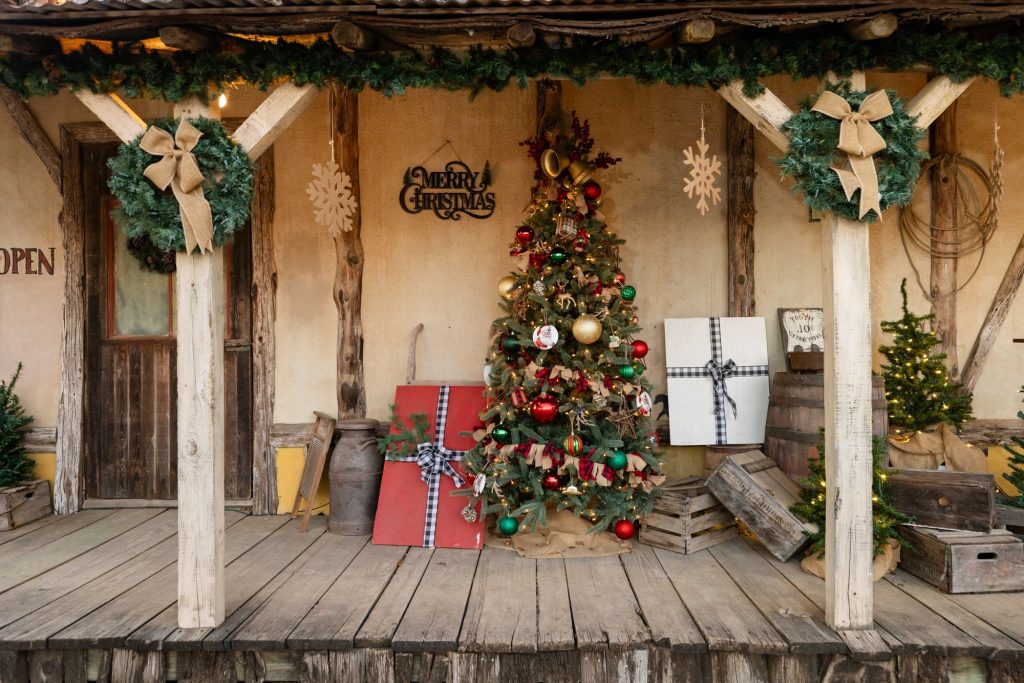Old West storefront porch decorated with a Christmas tree and garland