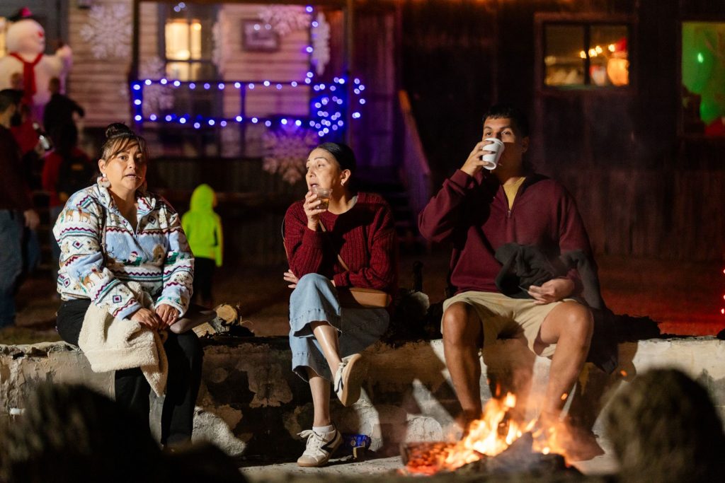 Guests roasting s'mores by the campfire at Old West Christmas Light Fest